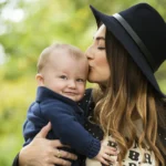 Portrait of a young mother kissing her baby son with love in a park in Winnetka IL.